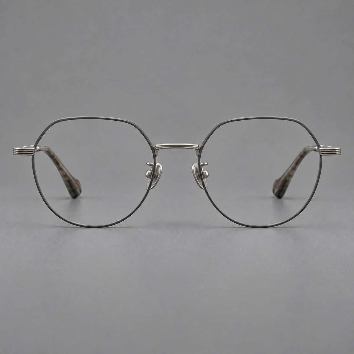 Geometric titanium glasses with soft polygonal rims and fine shoulder detailing in Grey and Silver, front view