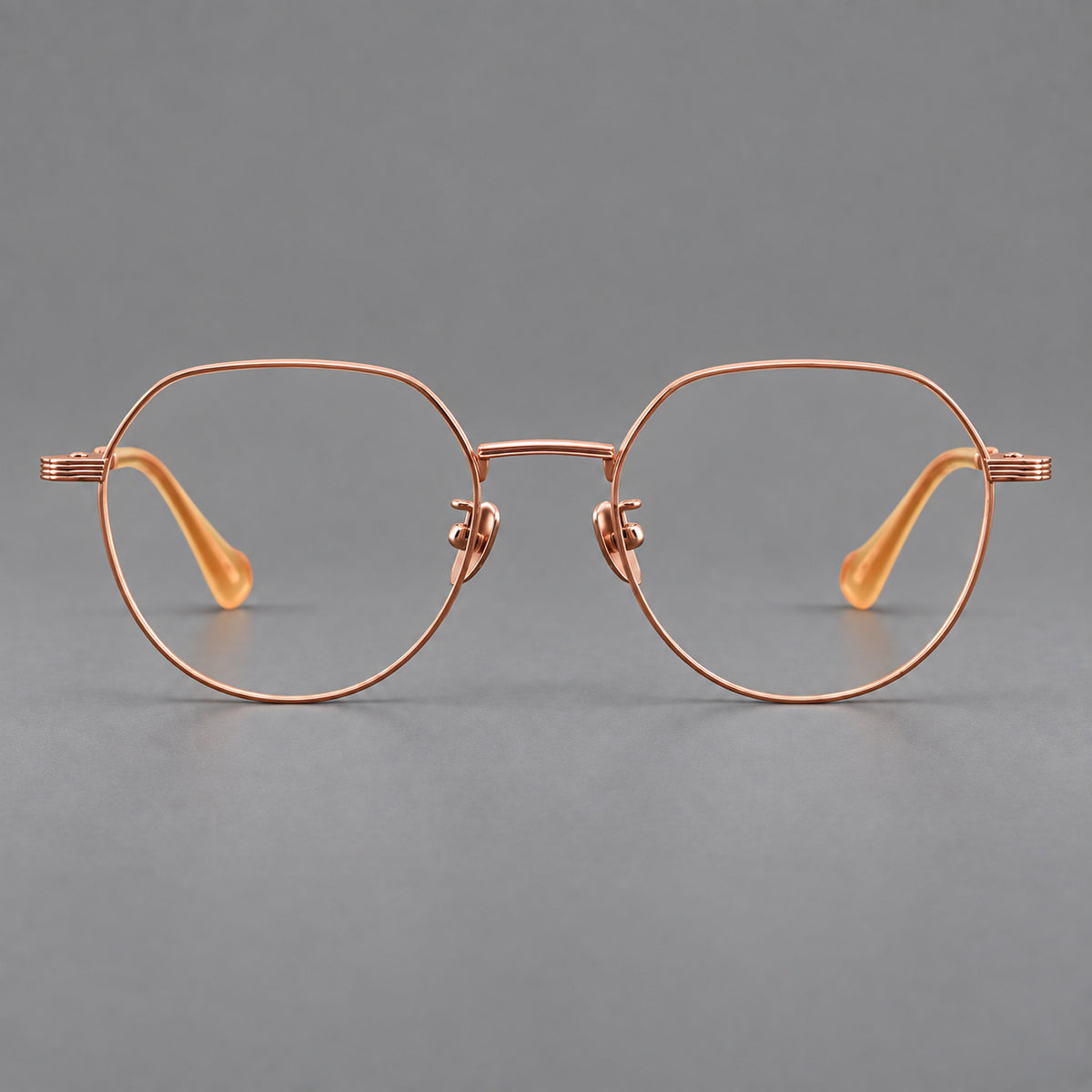 Geometric titanium glasses with soft polygonal rims and fine shoulder detailing in Rose Gold, front view