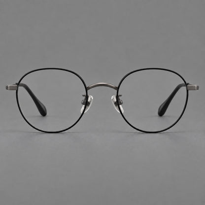 Compact round titanium glasses with an arched bridge and textured temple accents in Black and Gunmetal, front view frame detail