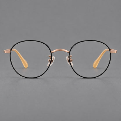 Compact round titanium glasses with an arched bridge and textured temple accents in Black and Rose Gold, front view temple detail