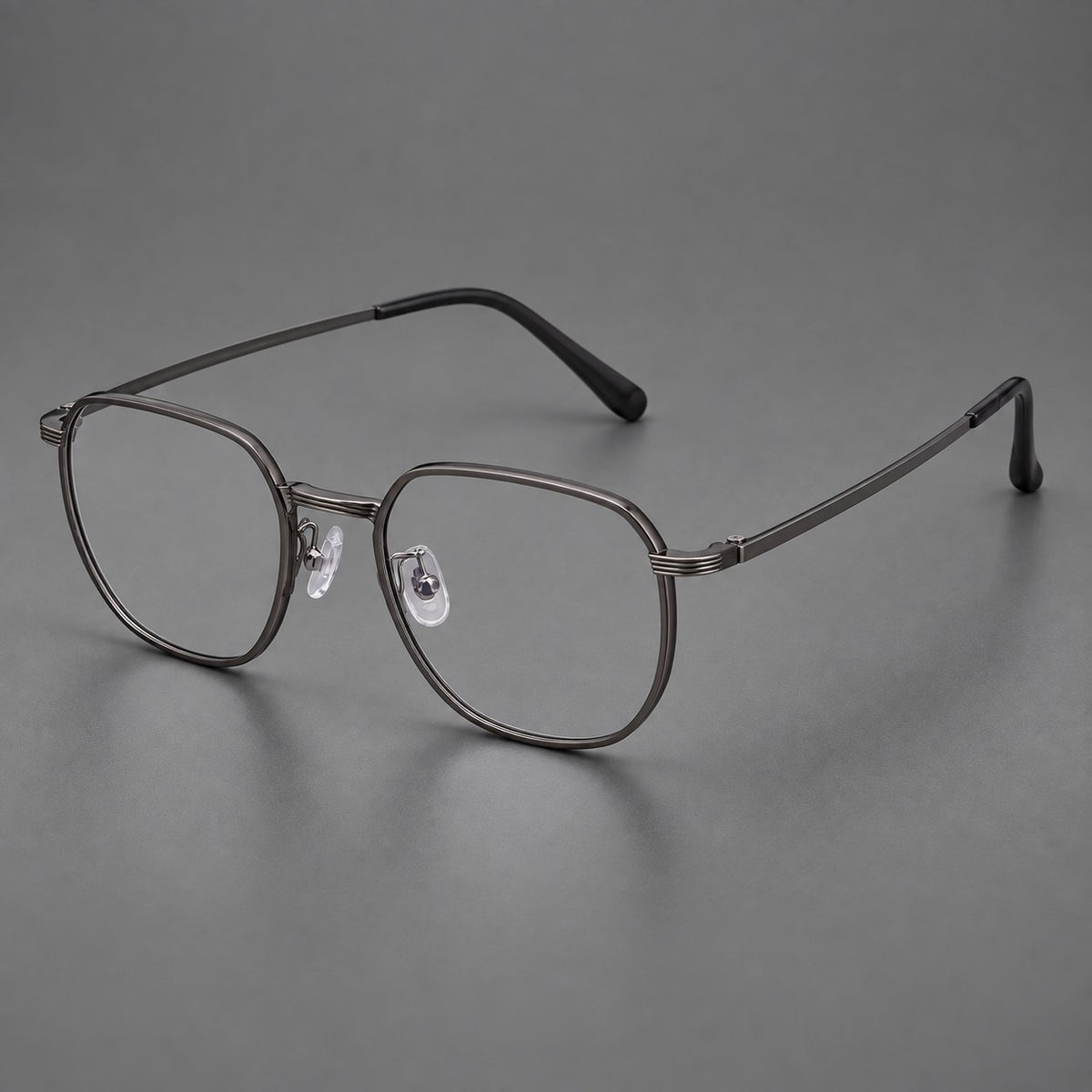 Geometric titanium glasses with flattened corners and a finely ridged bridge in Dark Grey, three quarter view