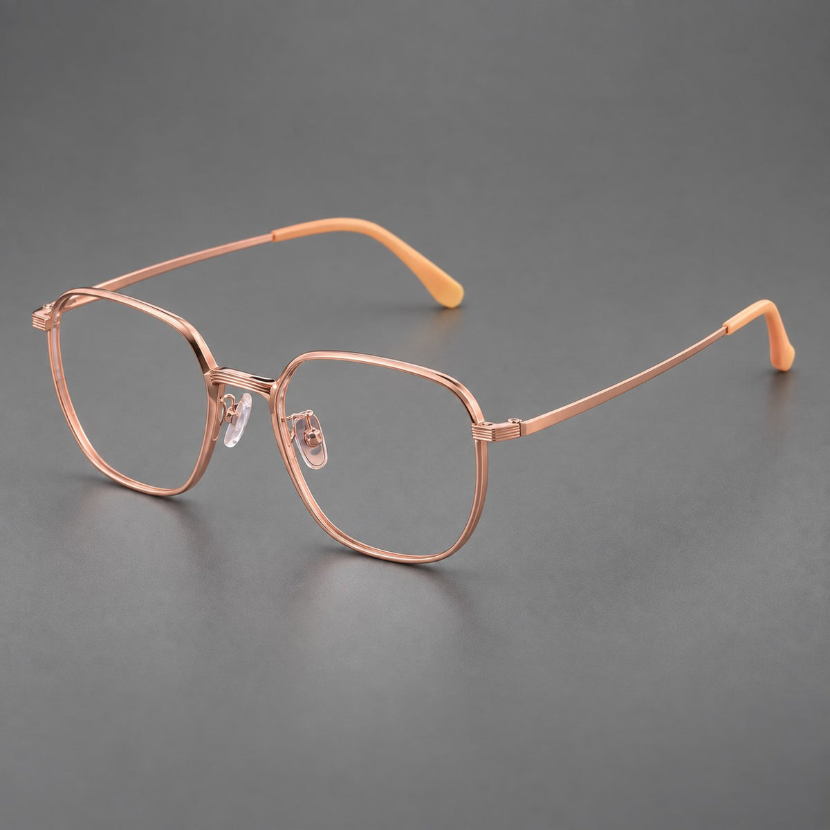 Geometric titanium glasses with flattened corners and a finely ridged bridge in Rose Gold, three quarter view