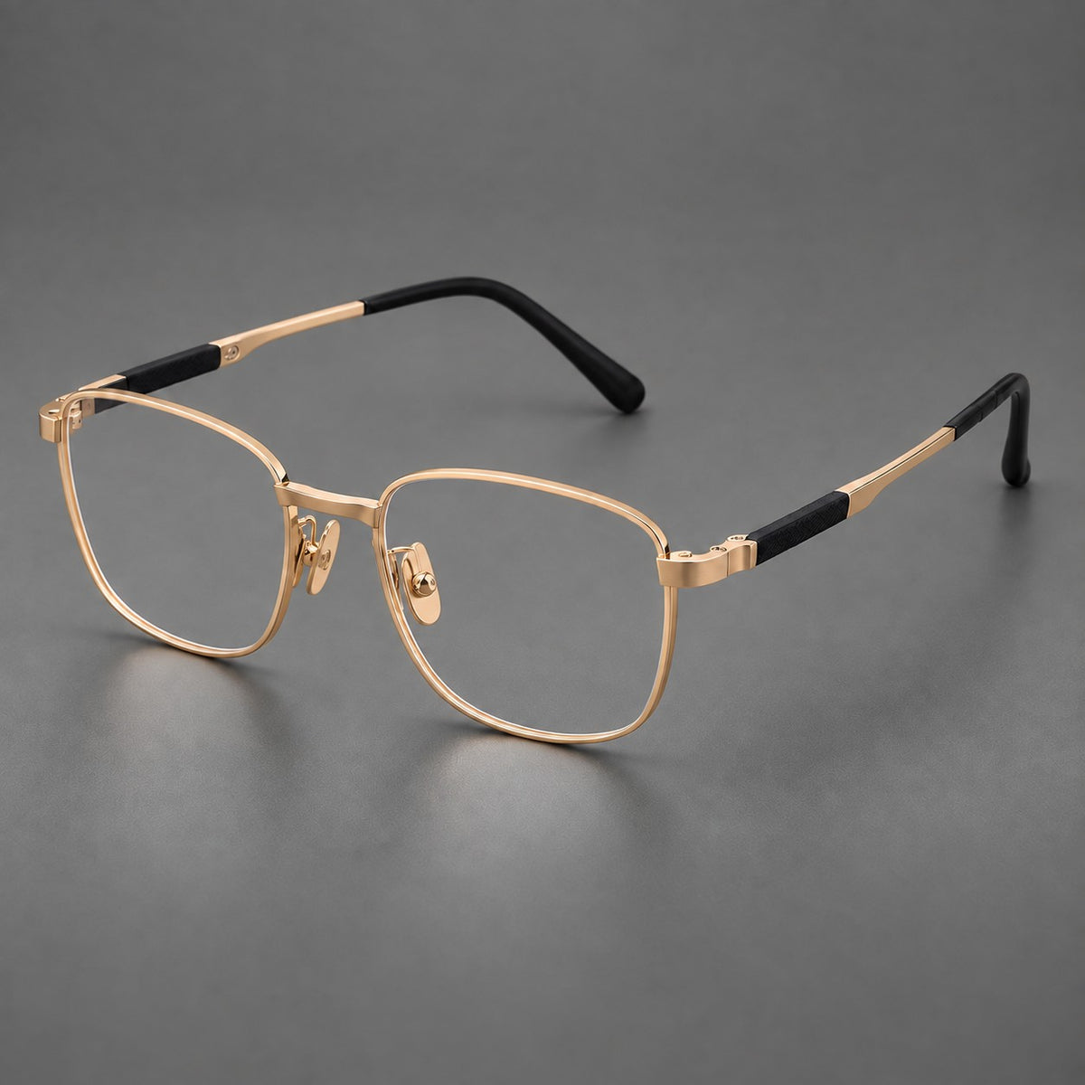 Slim rectangular titanium glasses with broad temples and contrasting dark inserts in Gold, three quarter view