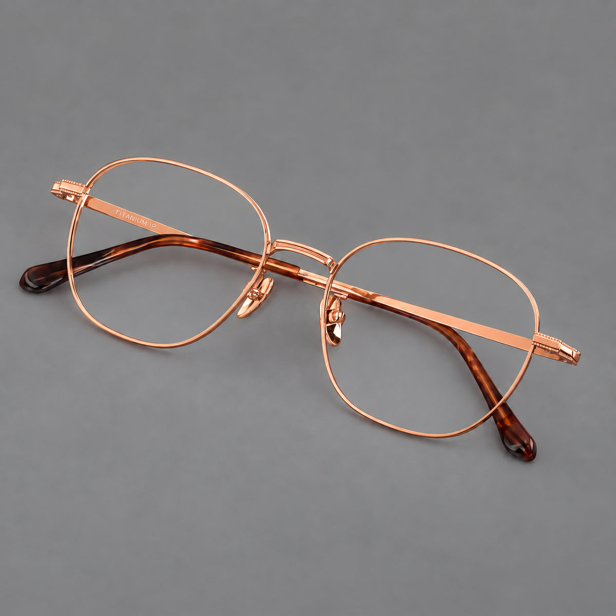 Retro panto titanium glasses with stepped corners and finely engraved temples in Rose Gold, three quarter view