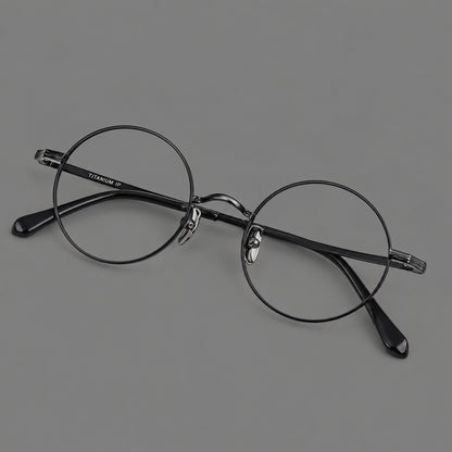 Compact circular titanium glasses with a curved bridge and wavy engraved temples in Black, three quarter view