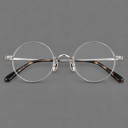 Compact circular titanium glasses with a curved bridge and wavy engraved temples in Silver, front view temple detail