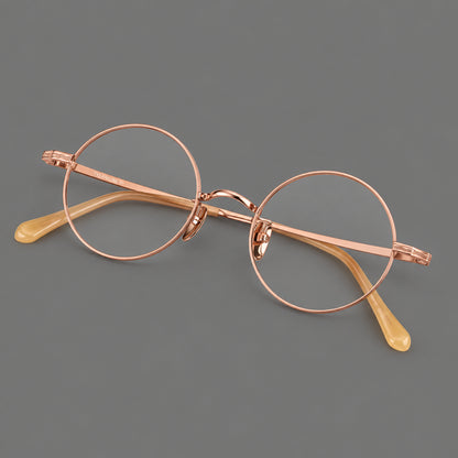 Compact circular titanium glasses with a curved bridge and wavy engraved temples in Rose Gold, three quarter view additional product view