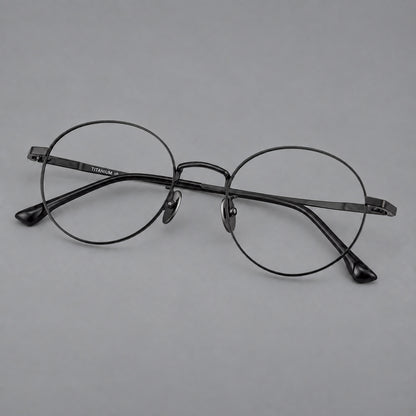 Classic circular titanium glasses with a raised bridge and lined temple accents in Black, three quarter view