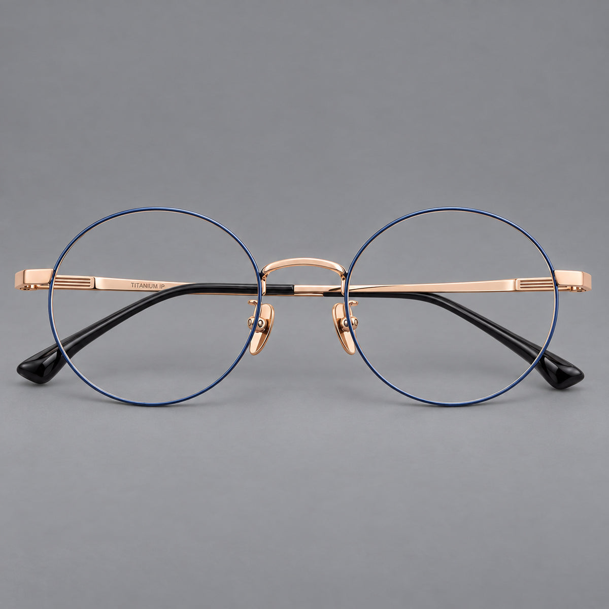 Classic circular titanium glasses with a raised bridge and lined temple accents in Blue and Gold, front view