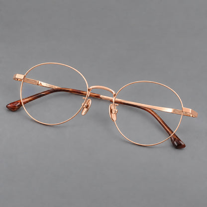Classic circular titanium glasses with a raised bridge and lined temple accents in Rose Gold, three quarter view additional product view