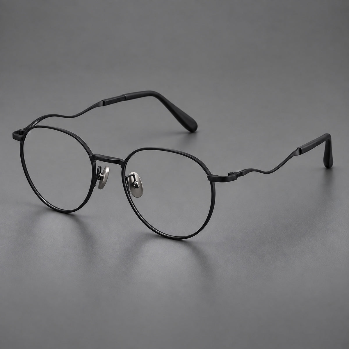 Rounded titanium glasses with a short bridge and distinctive wavy metal temples in Matte Black, three quarter view