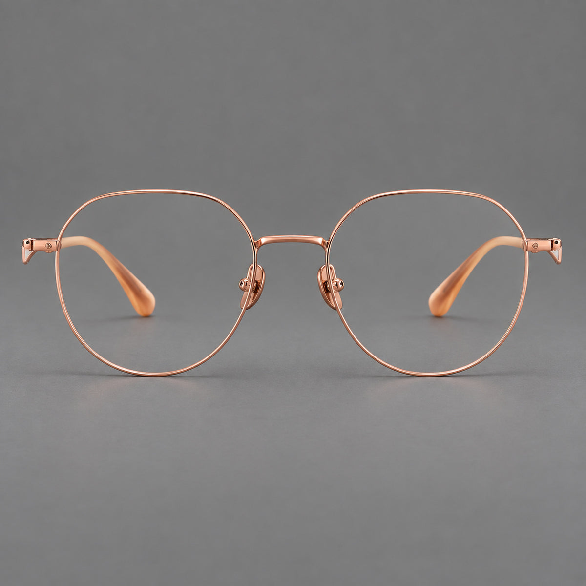 Rounded titanium glasses with a short bridge and distinctive wavy metal temples in Rose Gold, front view