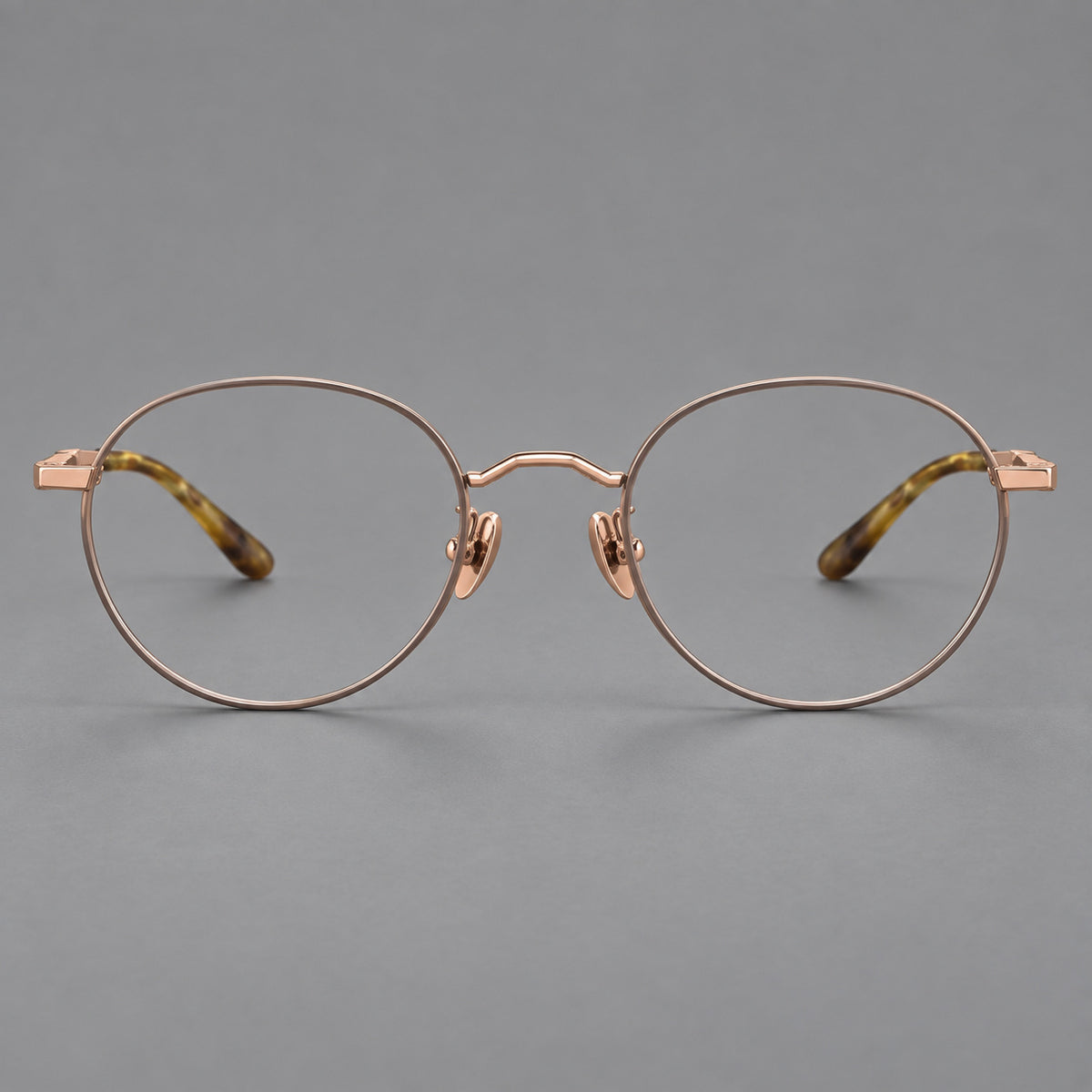 Retro panto titanium glasses with faceted corners and mottled curved temple tips in Grey Brown and Rose Gold, front view