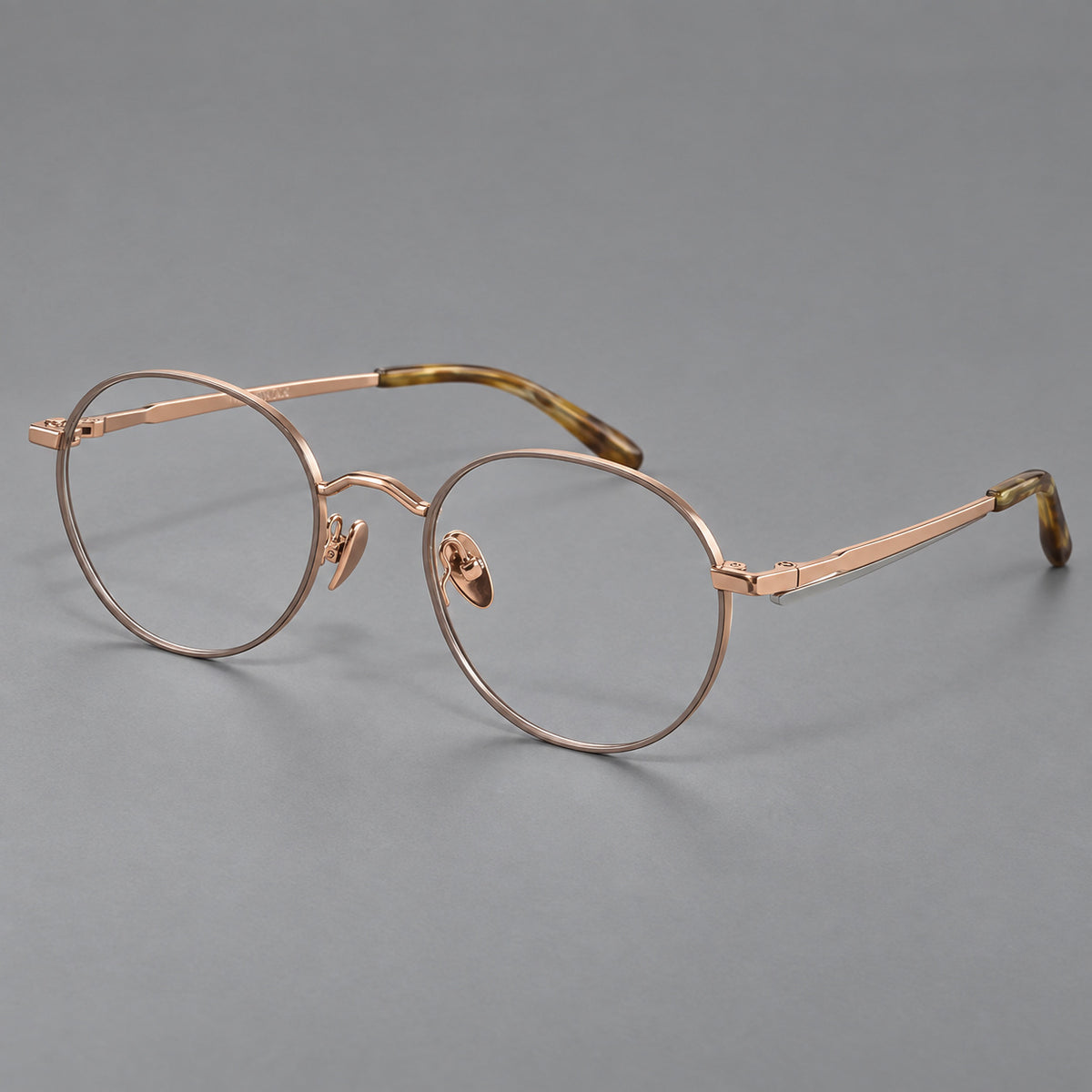 Retro panto titanium glasses with faceted corners and mottled curved temple tips in Grey Brown and Rose Gold, three quarter view