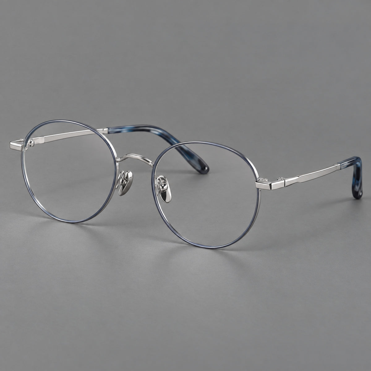 Retro panto titanium glasses with faceted corners and mottled curved temple tips in Grey Blue and Silver, three quarter view