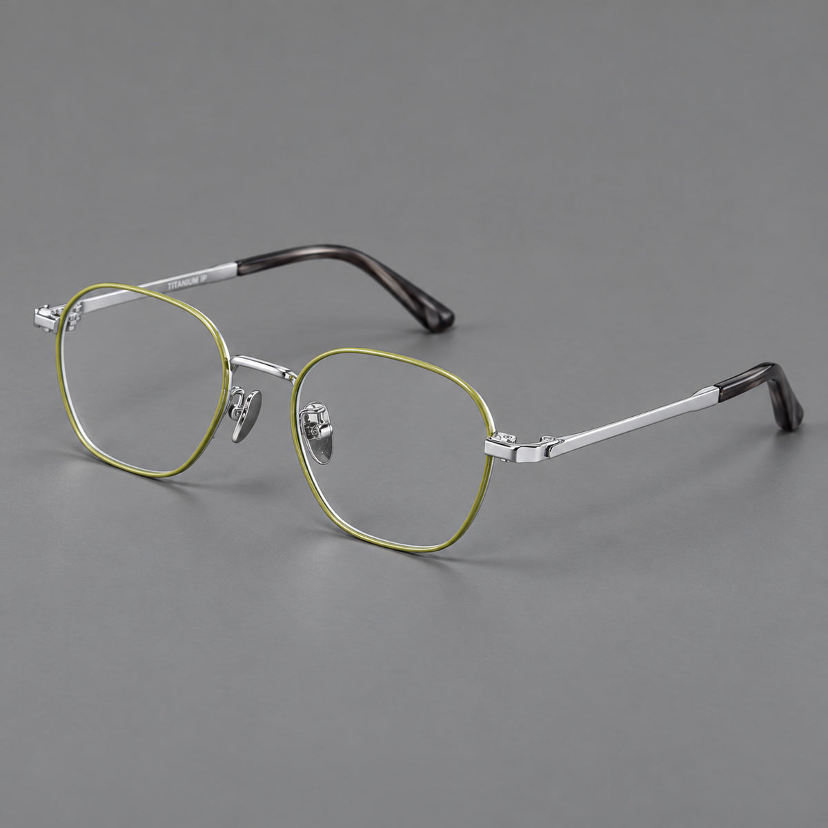 Rounded panto titanium glasses with an angular bridge and broad flat temples in Green and Silver, three quarter view