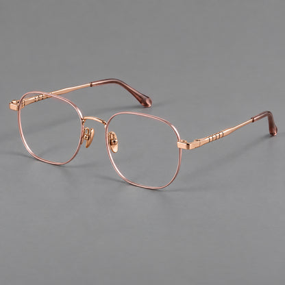 Soft square titanium glasses with a raised bridge and engraved temple bands in Pink and Rose Gold, three quarter view lens detail