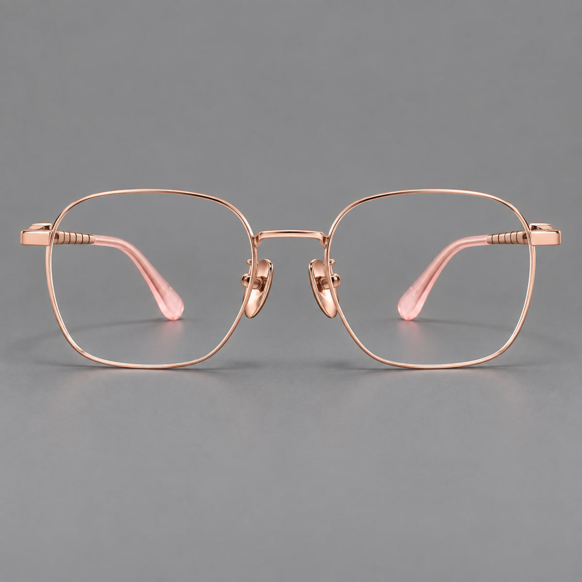 Soft square titanium glasses with a raised bridge and engraved temple bands in Rose Gold, front view