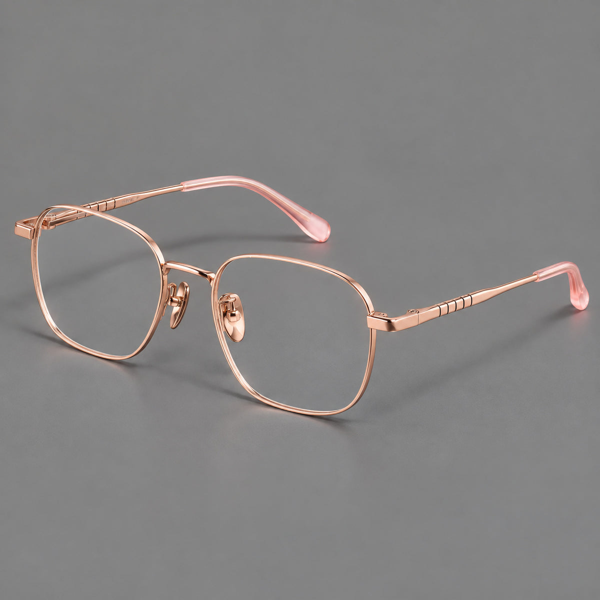 Soft square titanium glasses with a raised bridge and engraved temple bands in Rose Gold, three quarter view