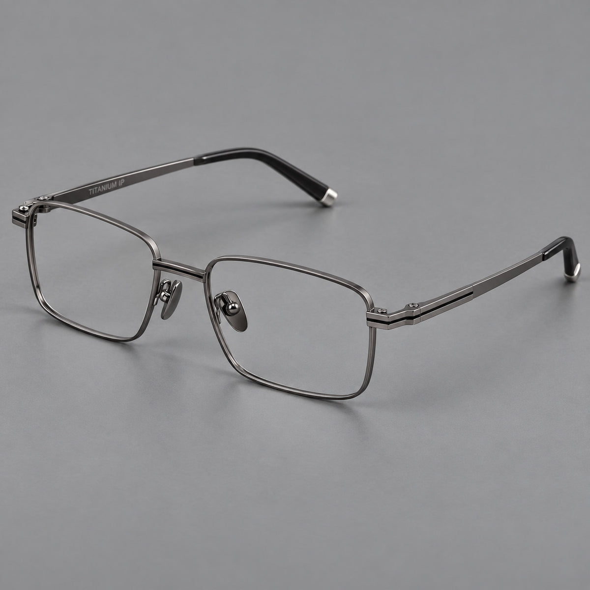Rectangular titanium glasses with inset corner lines and metal capped temple tips in Gunmetal, three quarter view