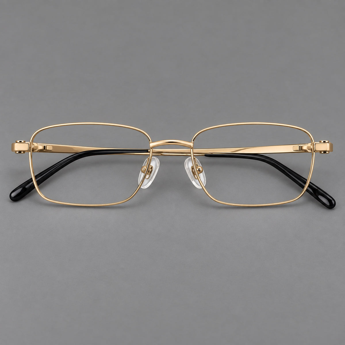 Shallow rectangular titanium glasses with a broad bridge and stepped temple joins in Gold, front view